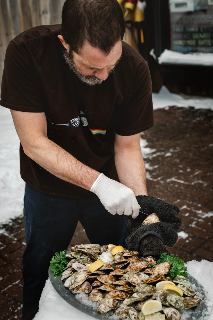 Shucking oysters outside the shop on a snowy Adirondack day